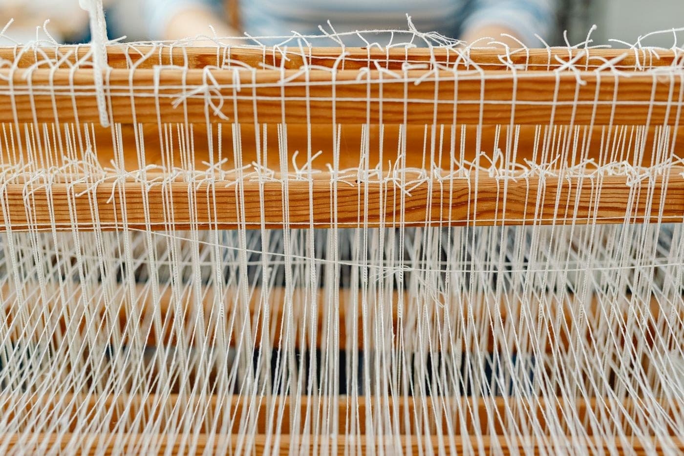 Teal and natural threads woven on a loom