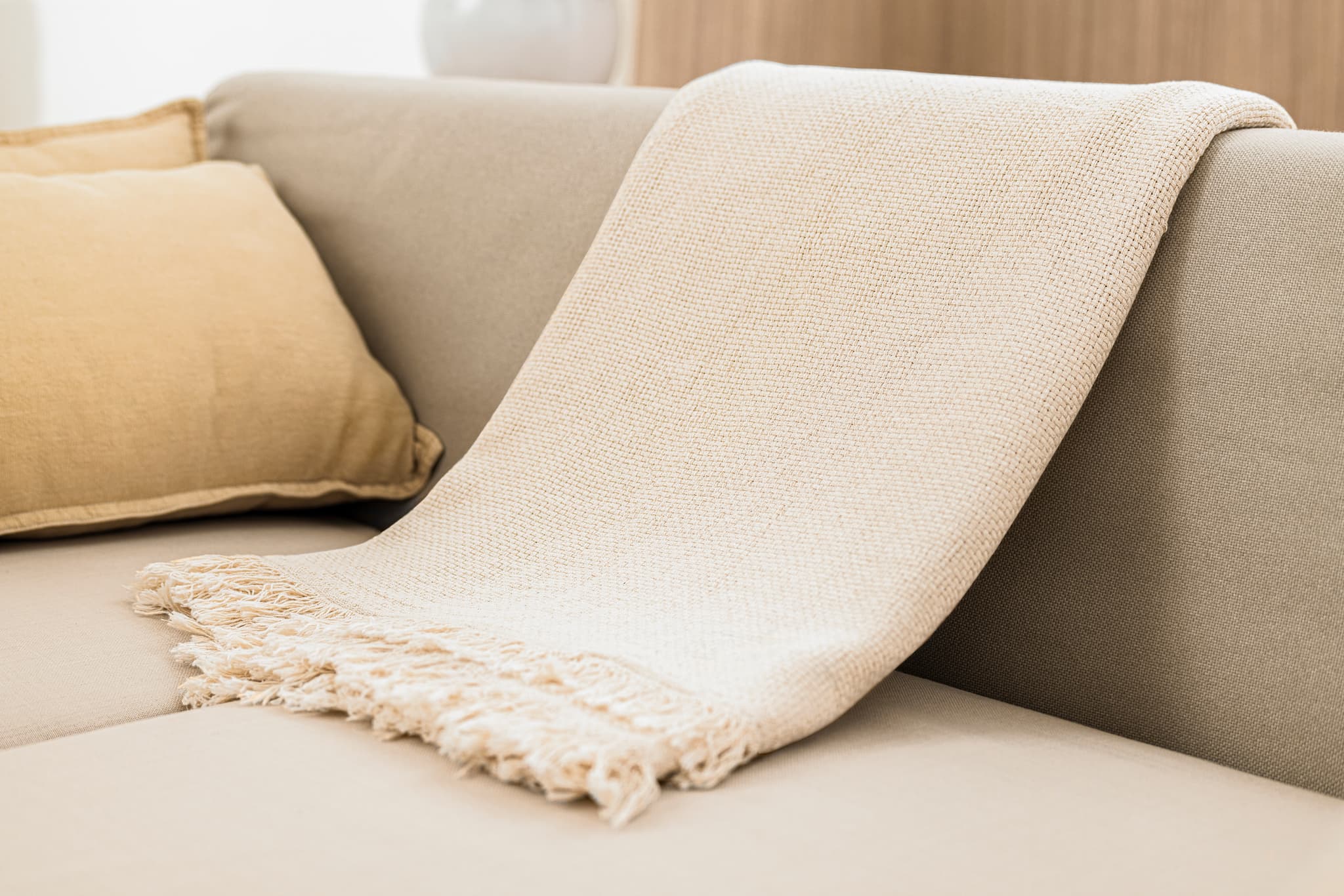 A soft knitted throw with tasselled edges