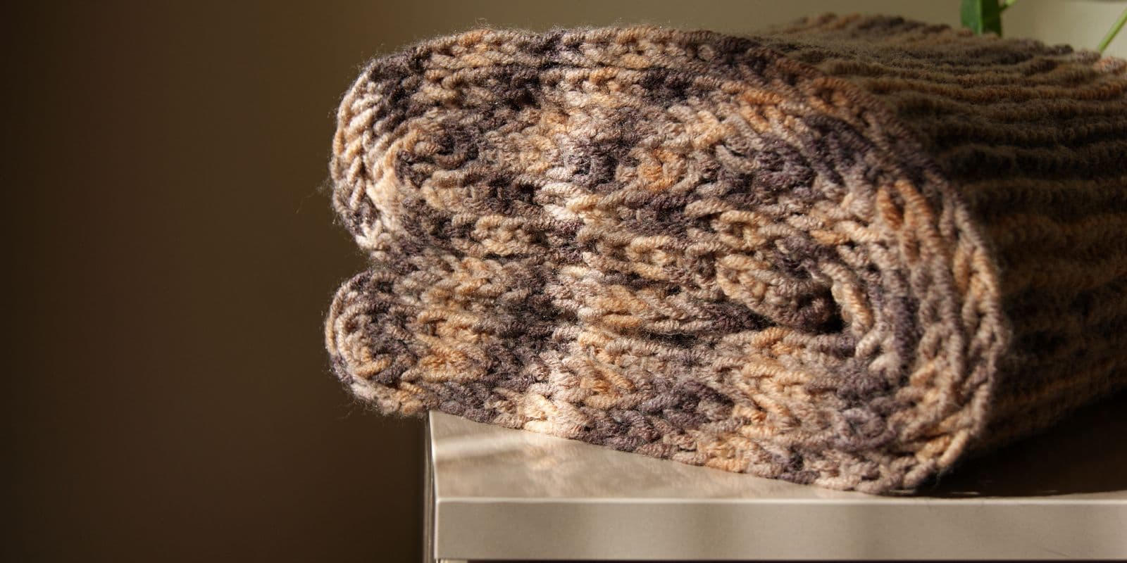 A folded chunky knit scarf in camel and charcoal