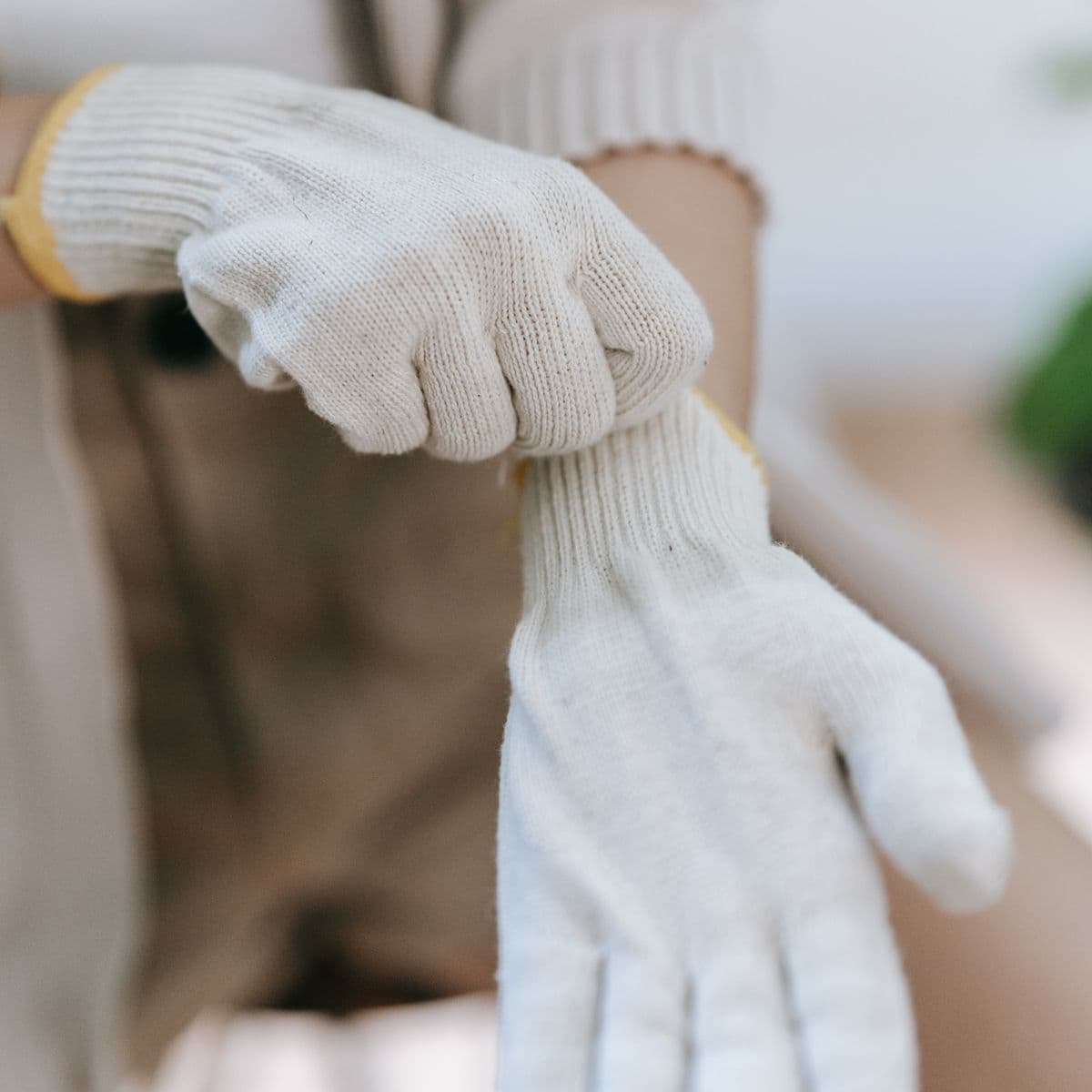 Hands wearing cream knit gloves
