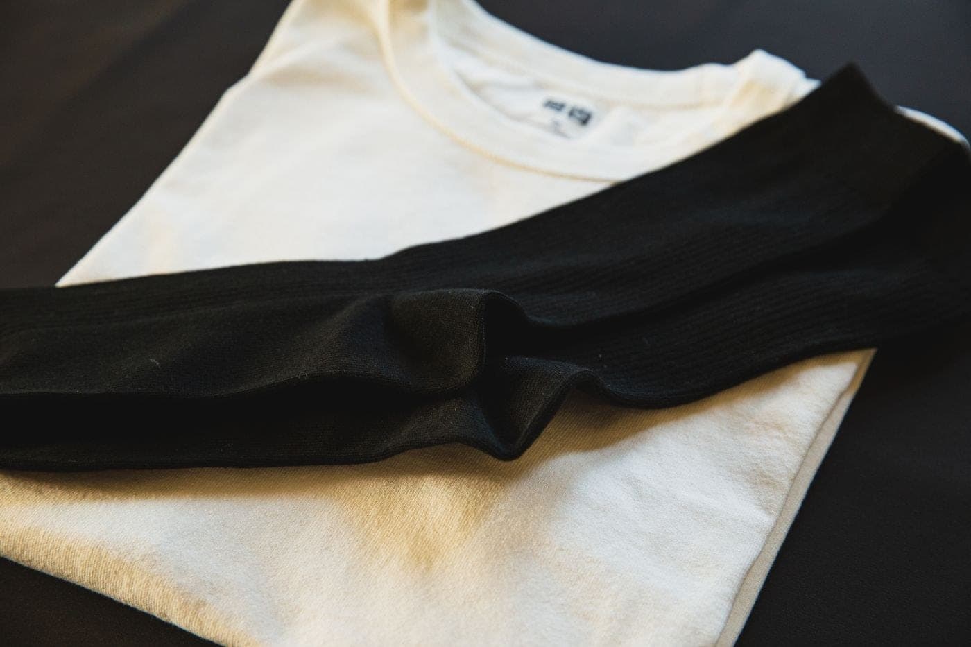 A stack of folded cream cotton t-shirts