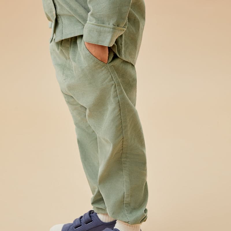 A child in sage corduroy trousers