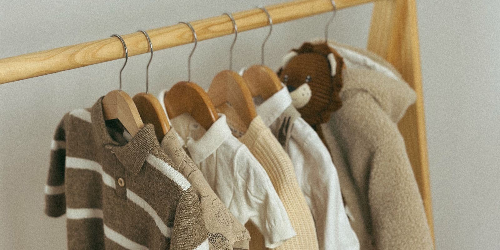A rail of hung baby clothes in soft neutral tones