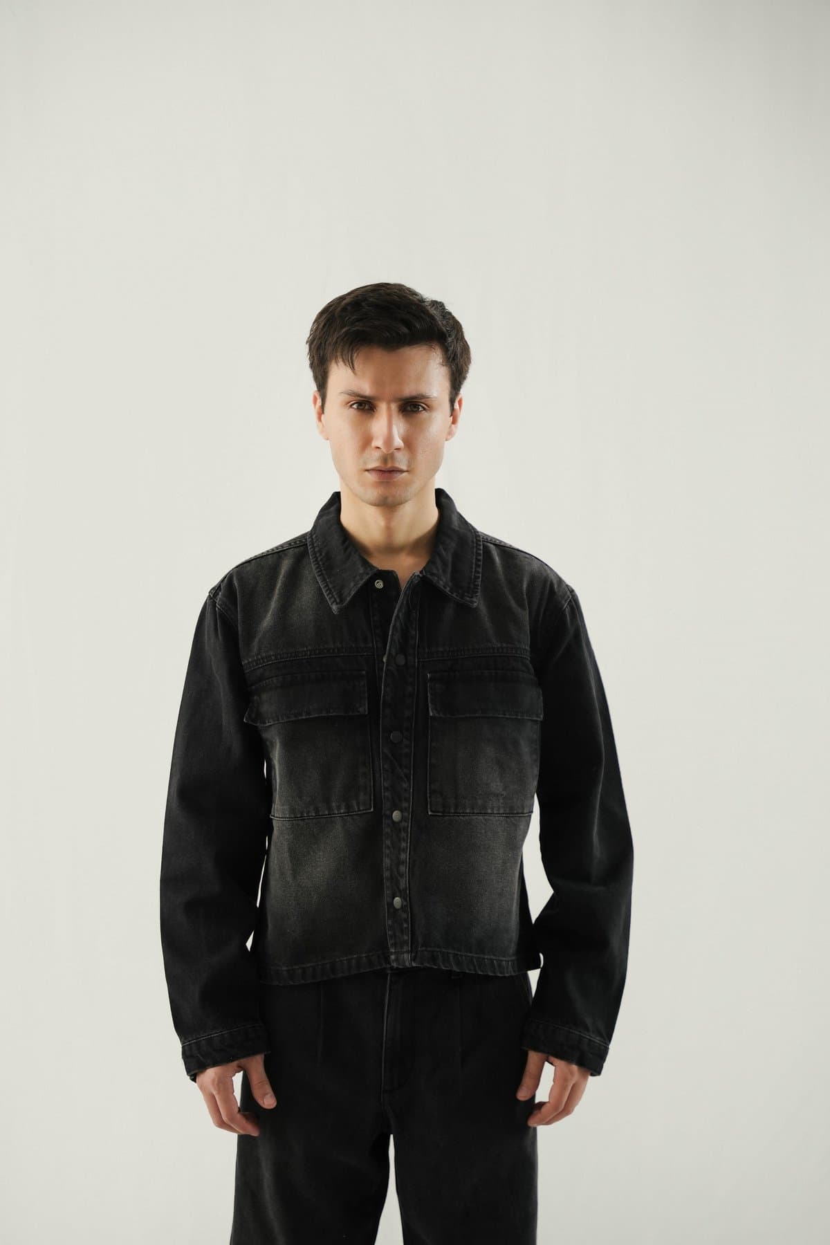 Male model in a cropped black stone-wash denim jacket