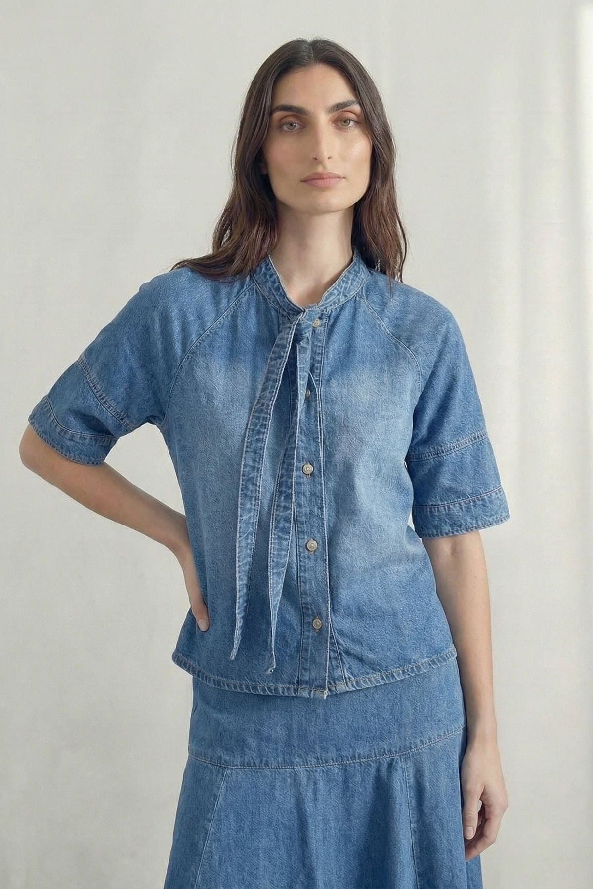Female model in a mid-blue puff-sleeve denim top