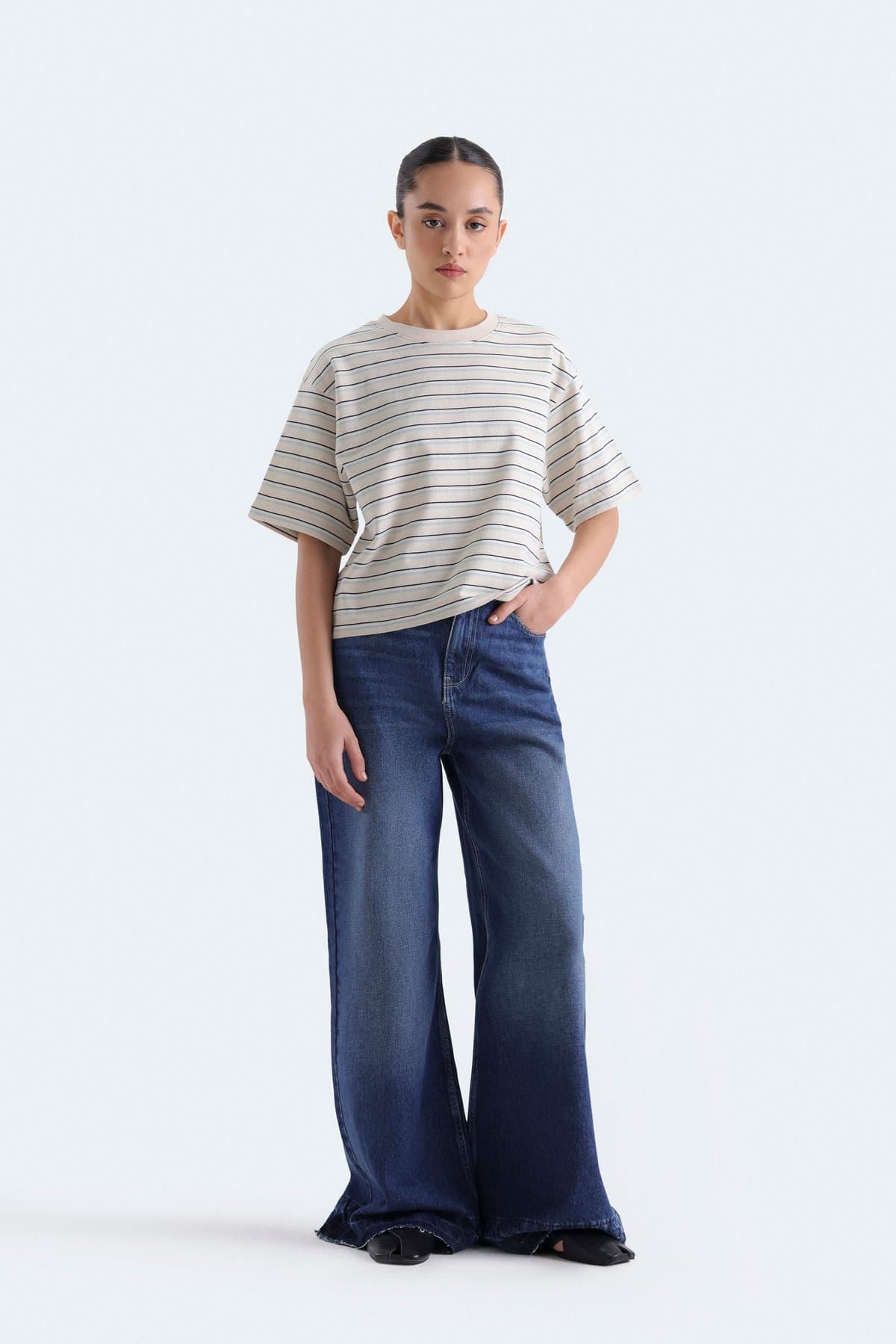 Female model in white wide-leg jeans with a denim waistcoat