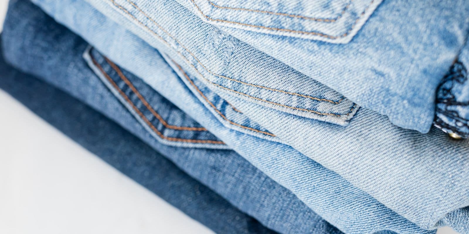 Rows of folded jeans from light to dark wash