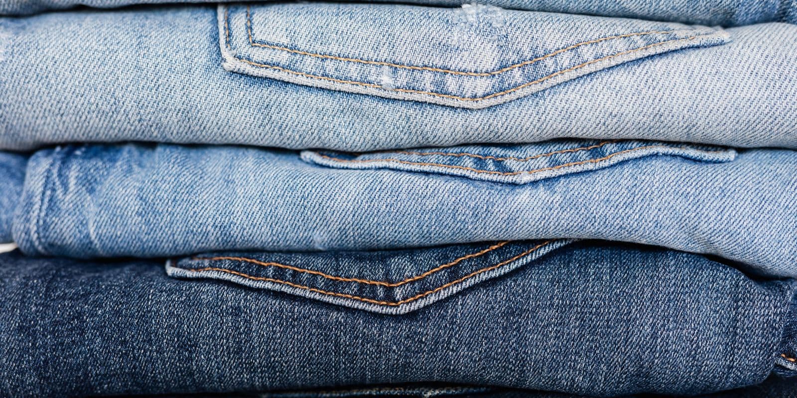 A row of folded mid-indigo jeans