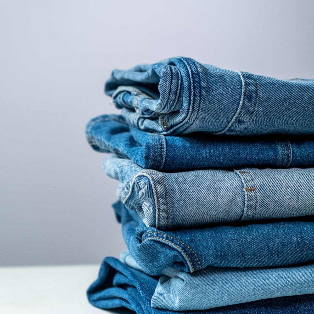 A stack of folded jeans in light and mid washes