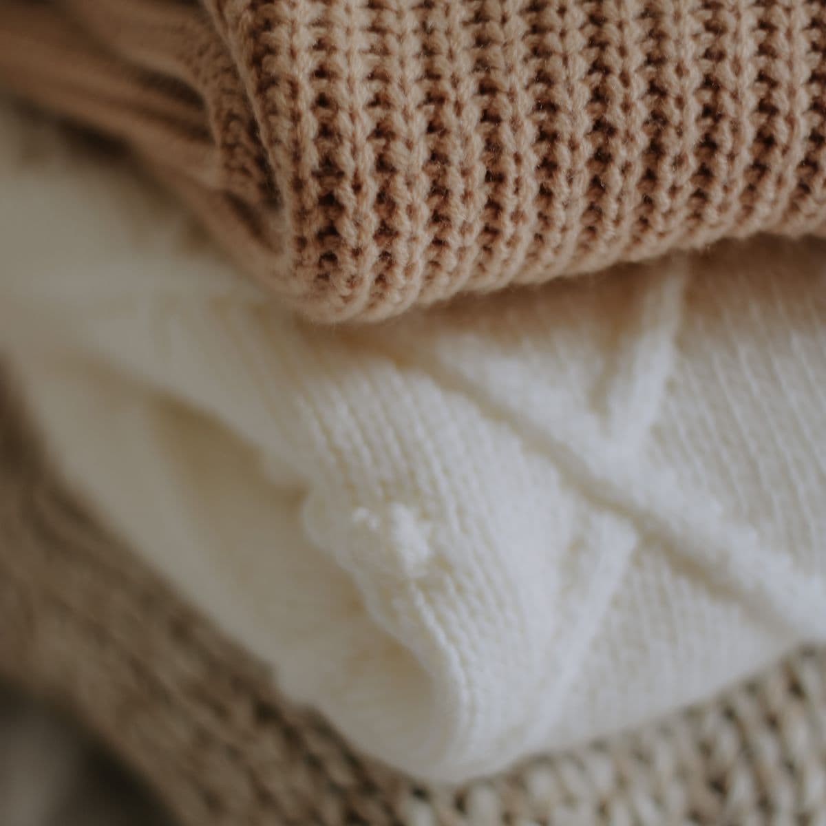 Close-up of folded tan and ivory knit basics
