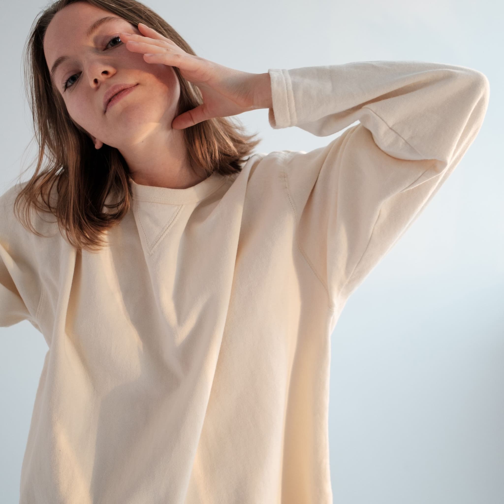 Woman in a cream oversized sweatshirt