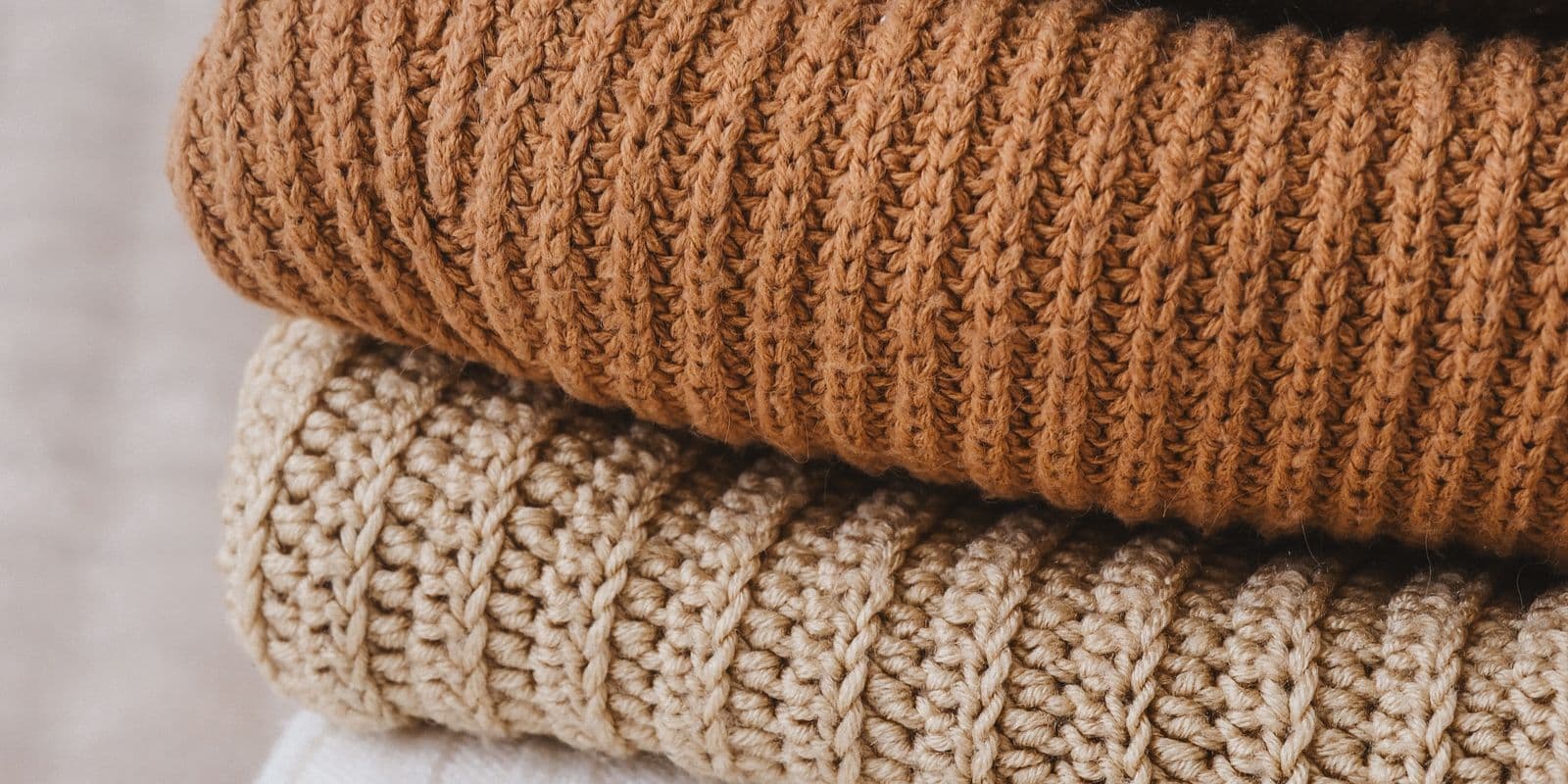 Folded camel and oatmeal ribbed knit sweaters