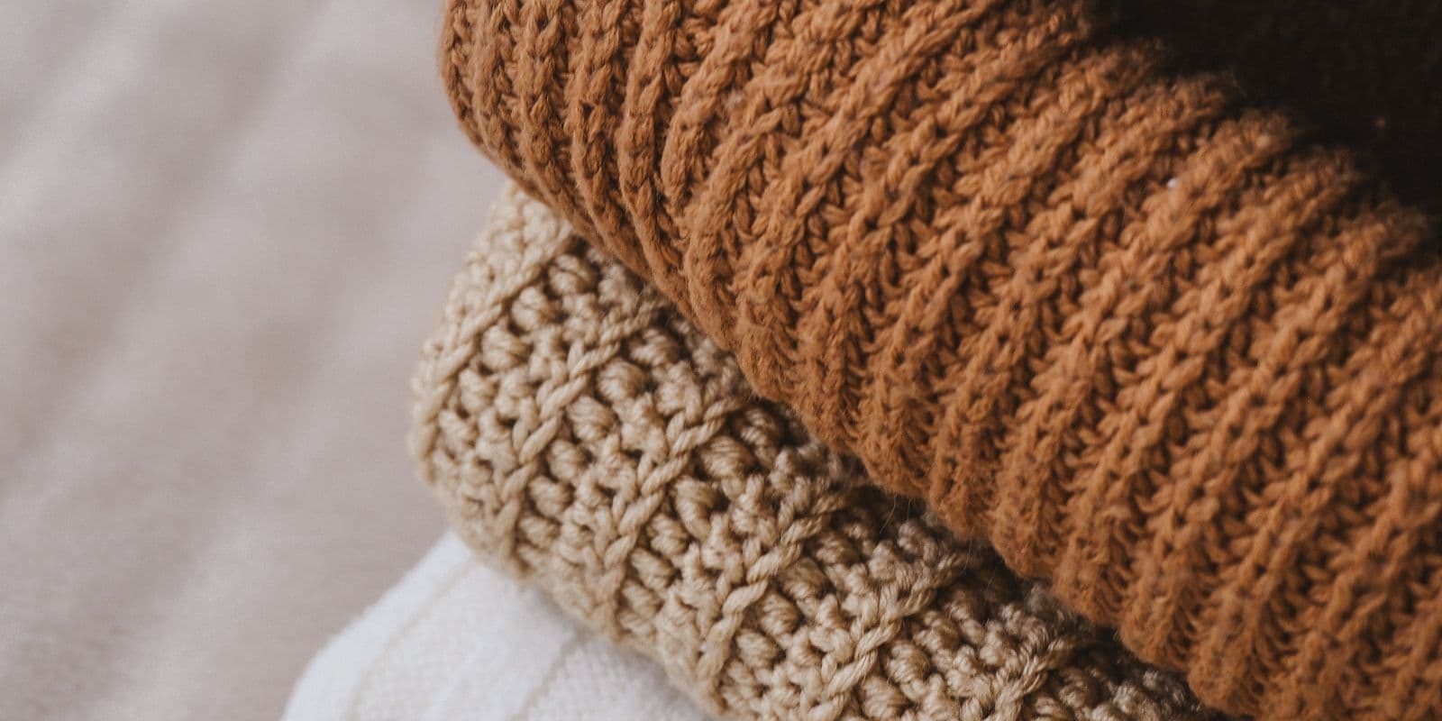 Camel and oatmeal ribbed sweaters folded in a row