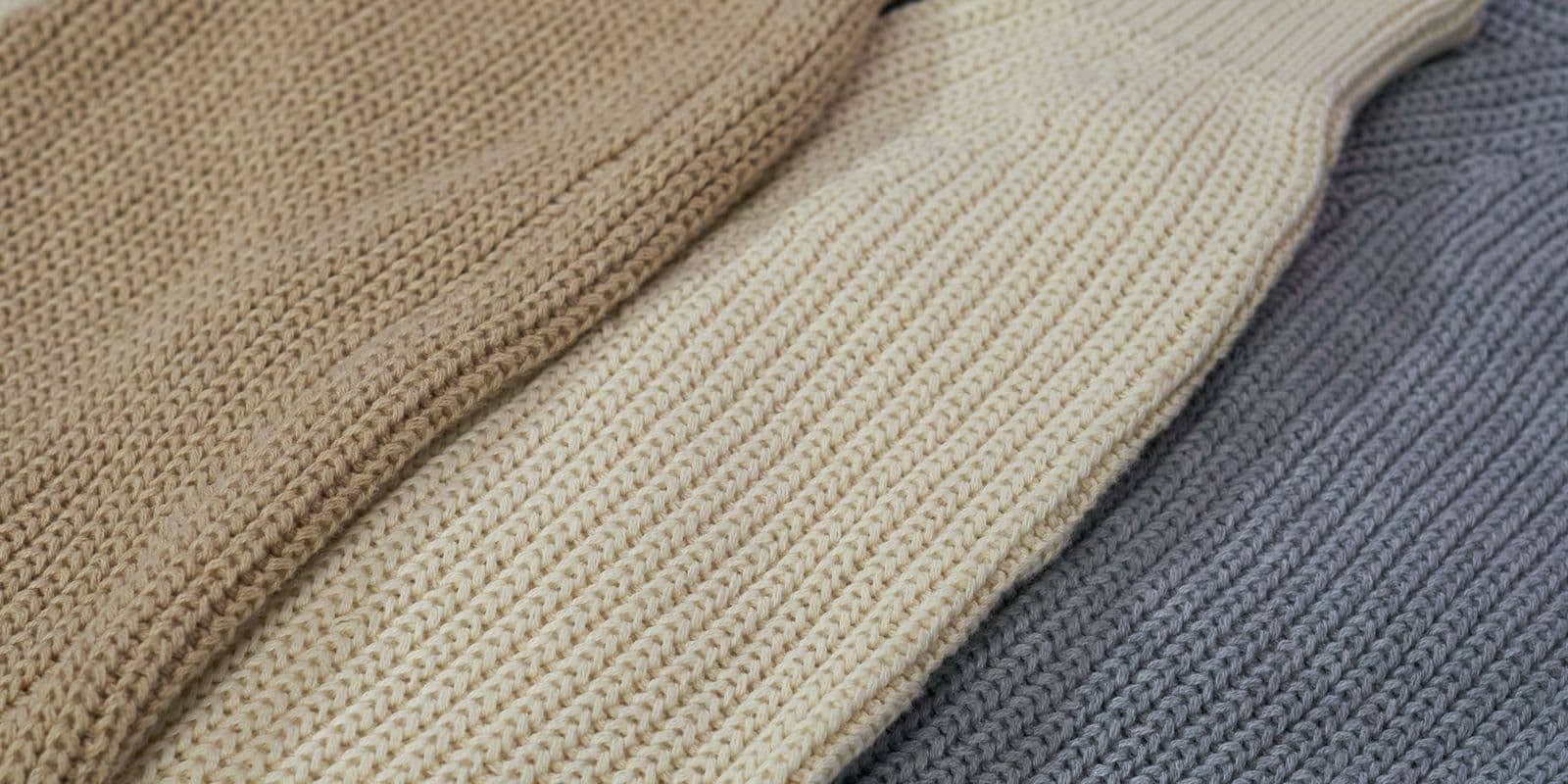 Beige, cream and grey ribbed knits laid out