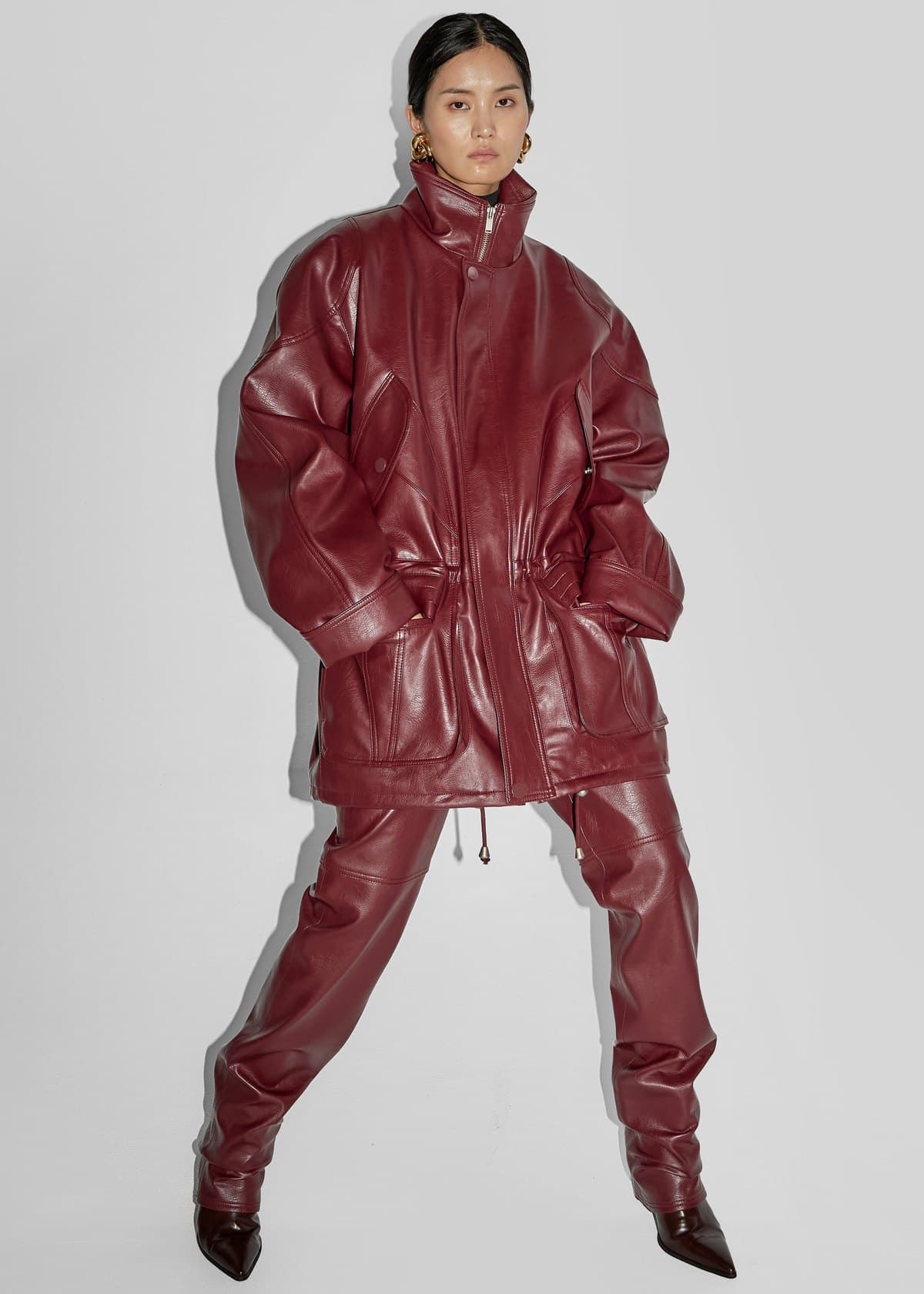 Model in an oversized burgundy leather jacket