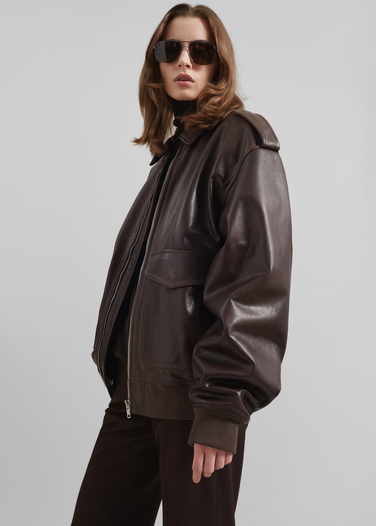 Model in a brown leather bomber jacket