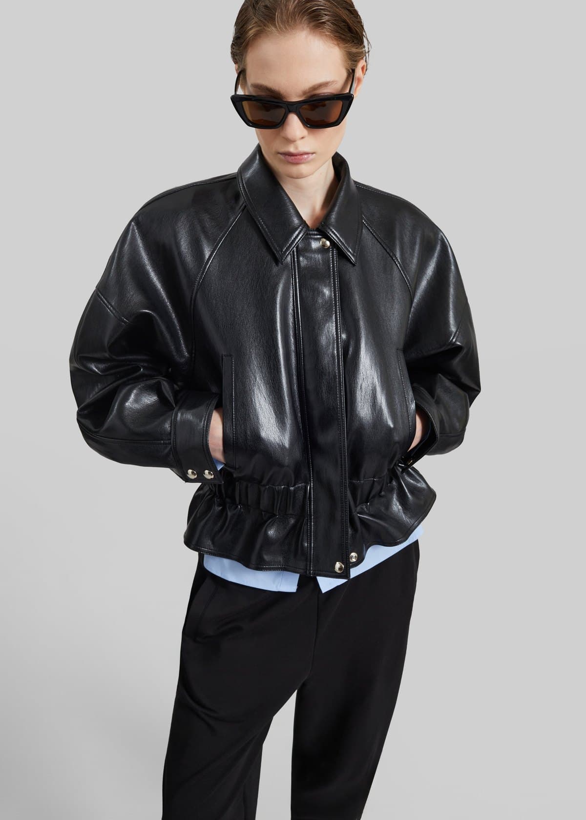Model in a black leather peplum jacket
