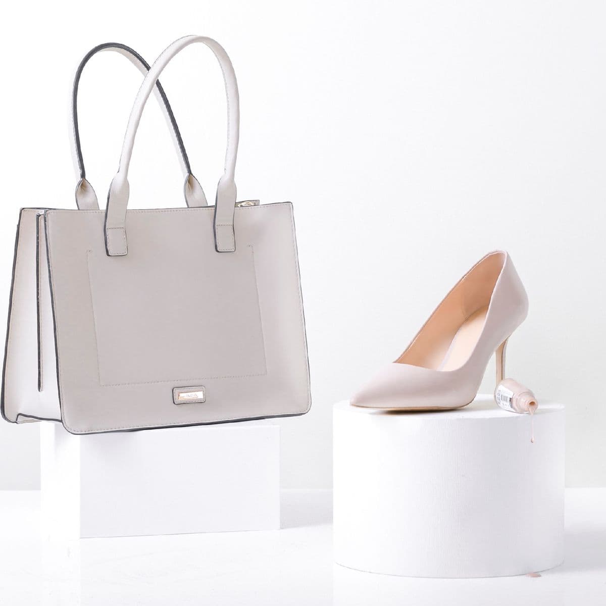 A stone-grey leather tote on a pedestal