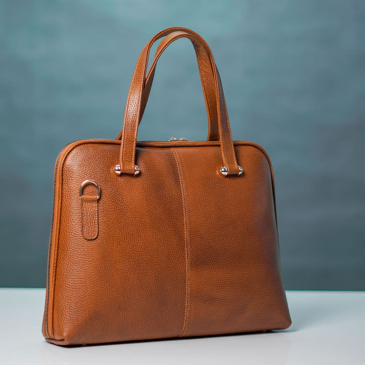 A tan leather handbag on a clean surface
