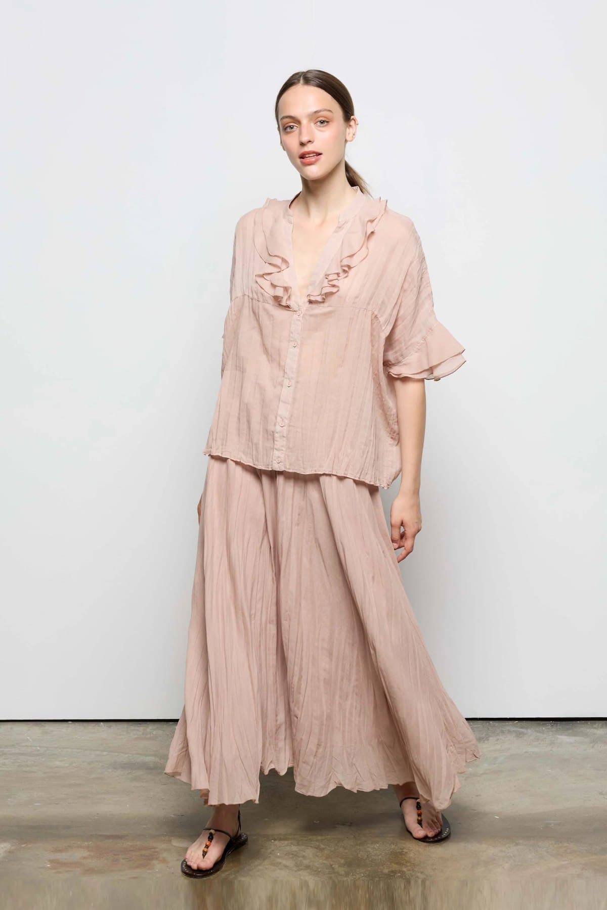 Model in a taupe pleated A-line midi skirt