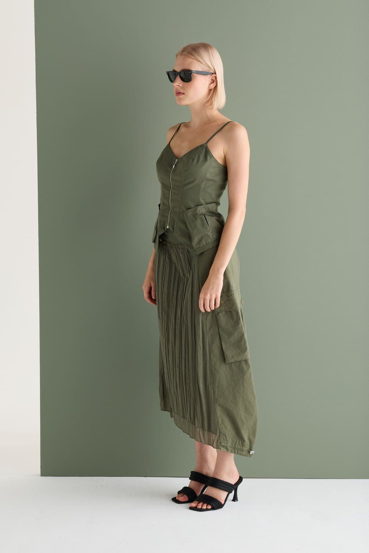 Side view of a sage pleated midi skirt