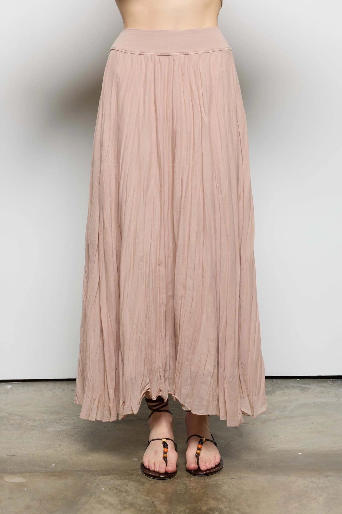 Side view of a taupe pleated A-line midi skirt