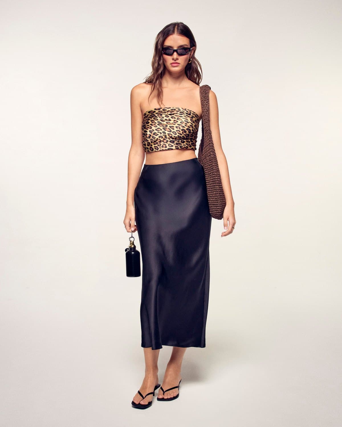 Model in a black bias-cut satin midi skirt