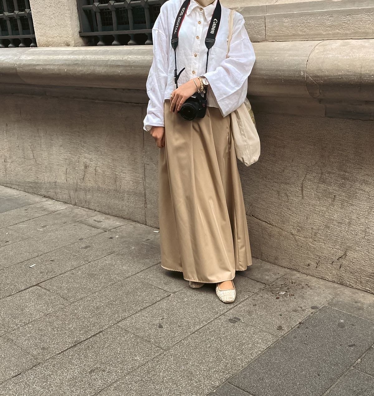 Model in a camel flared maxi skirt