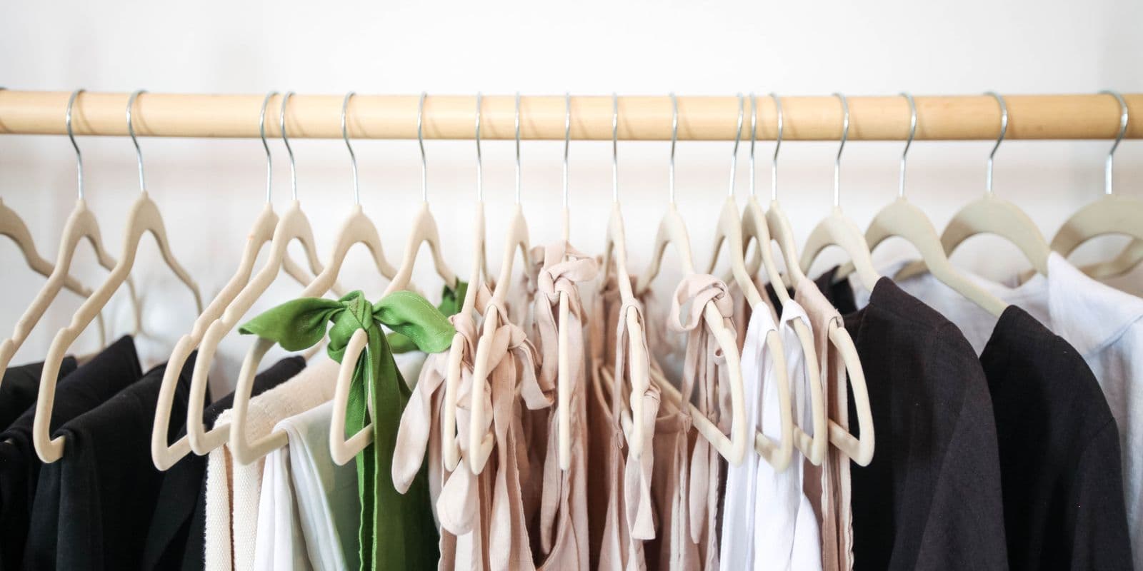 A rail of neutral dresses on cream velvet hangers