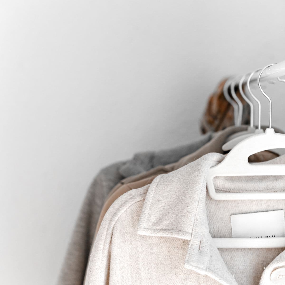 Soft neutral garments on white hangers