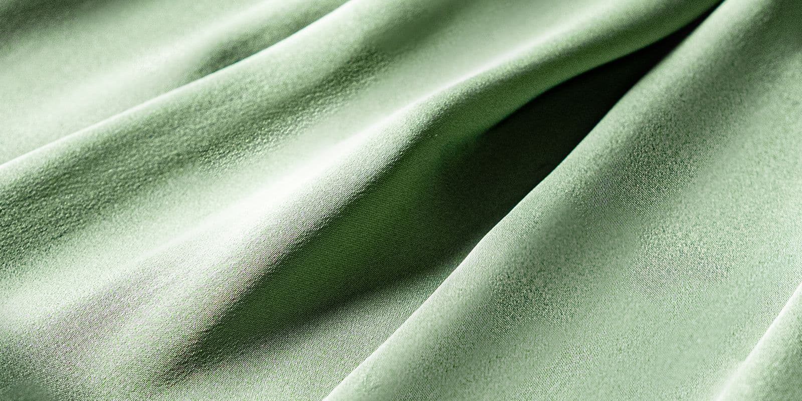 Soft sage-green fabric draped in gentle folds
