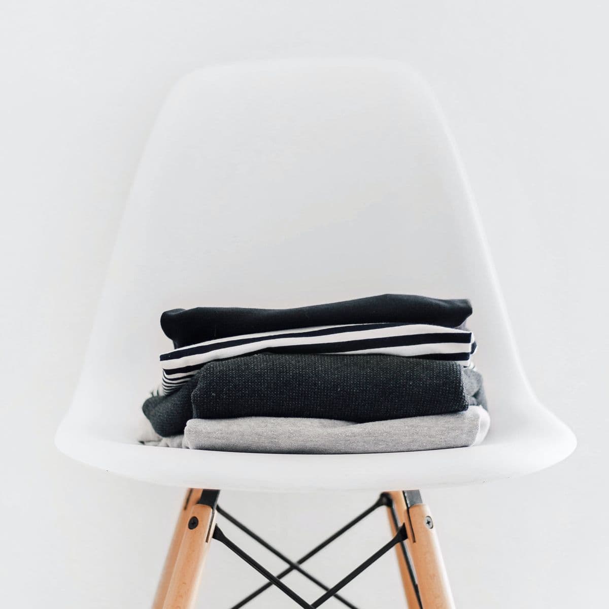 A folded stack of charcoal, grey and white garments