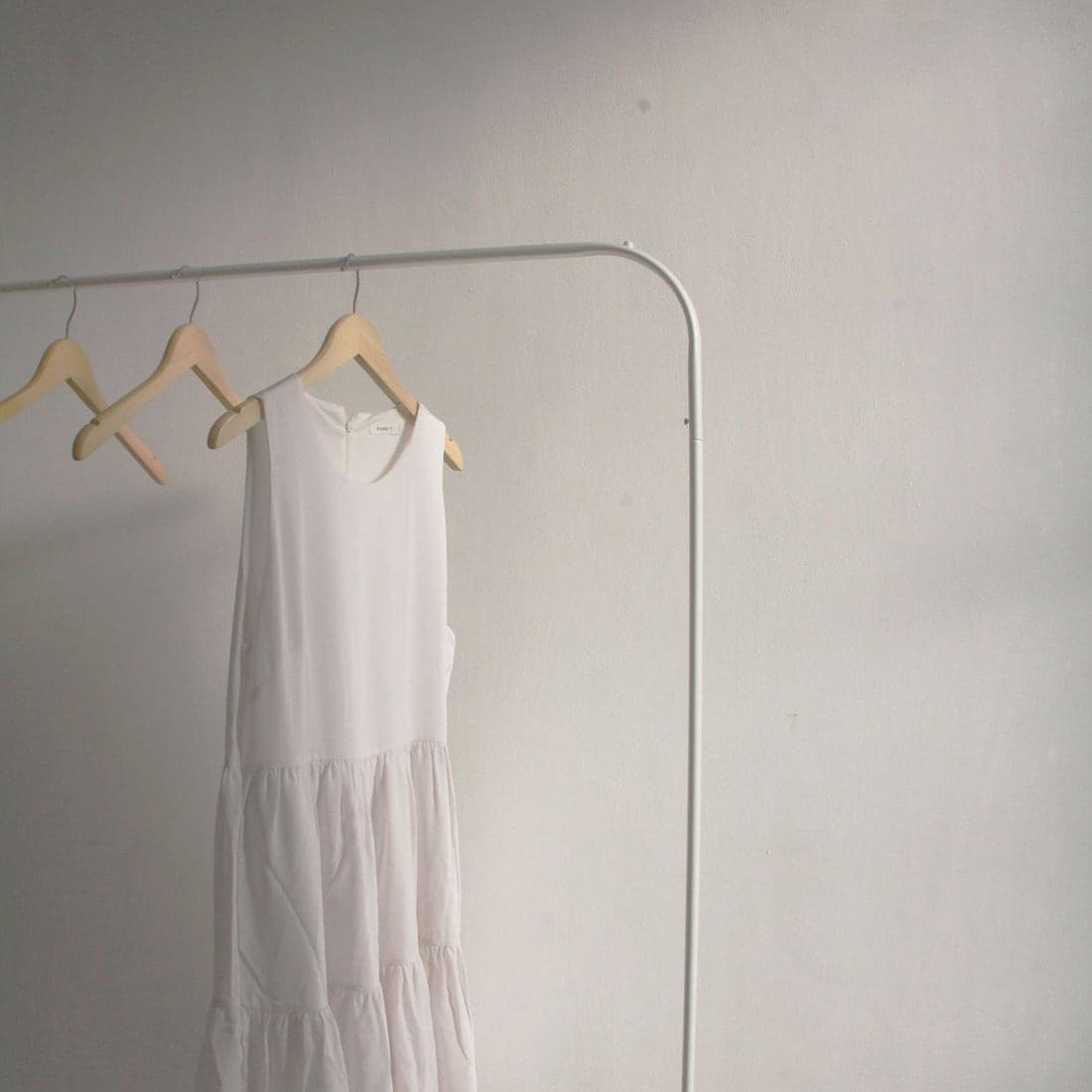 A crisp white garment on a clean minimal studio rail