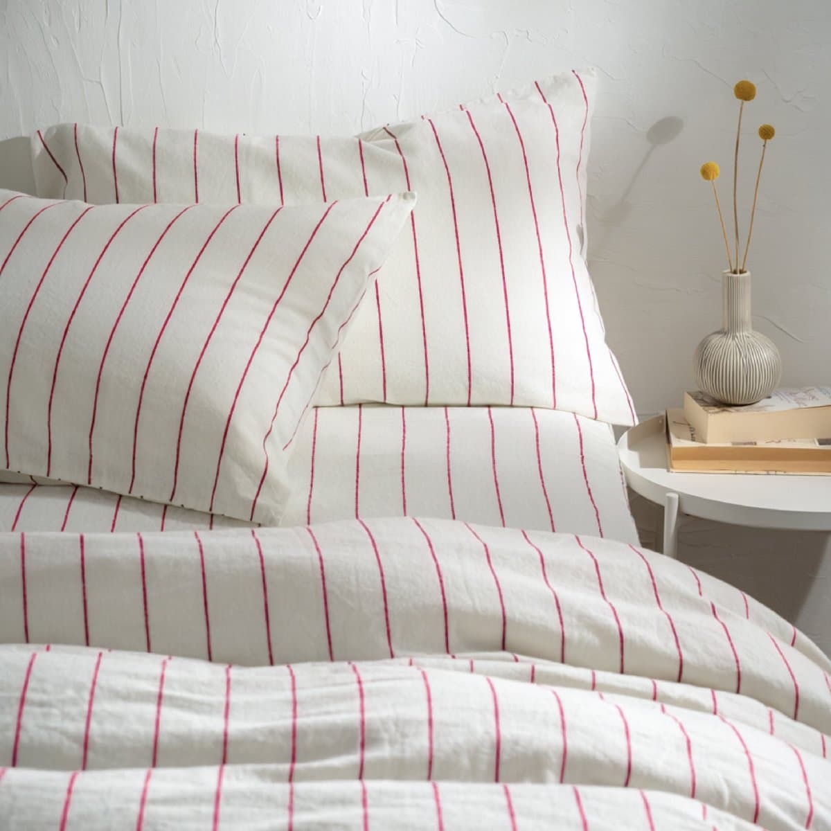 A white striped draw sheet on a bed