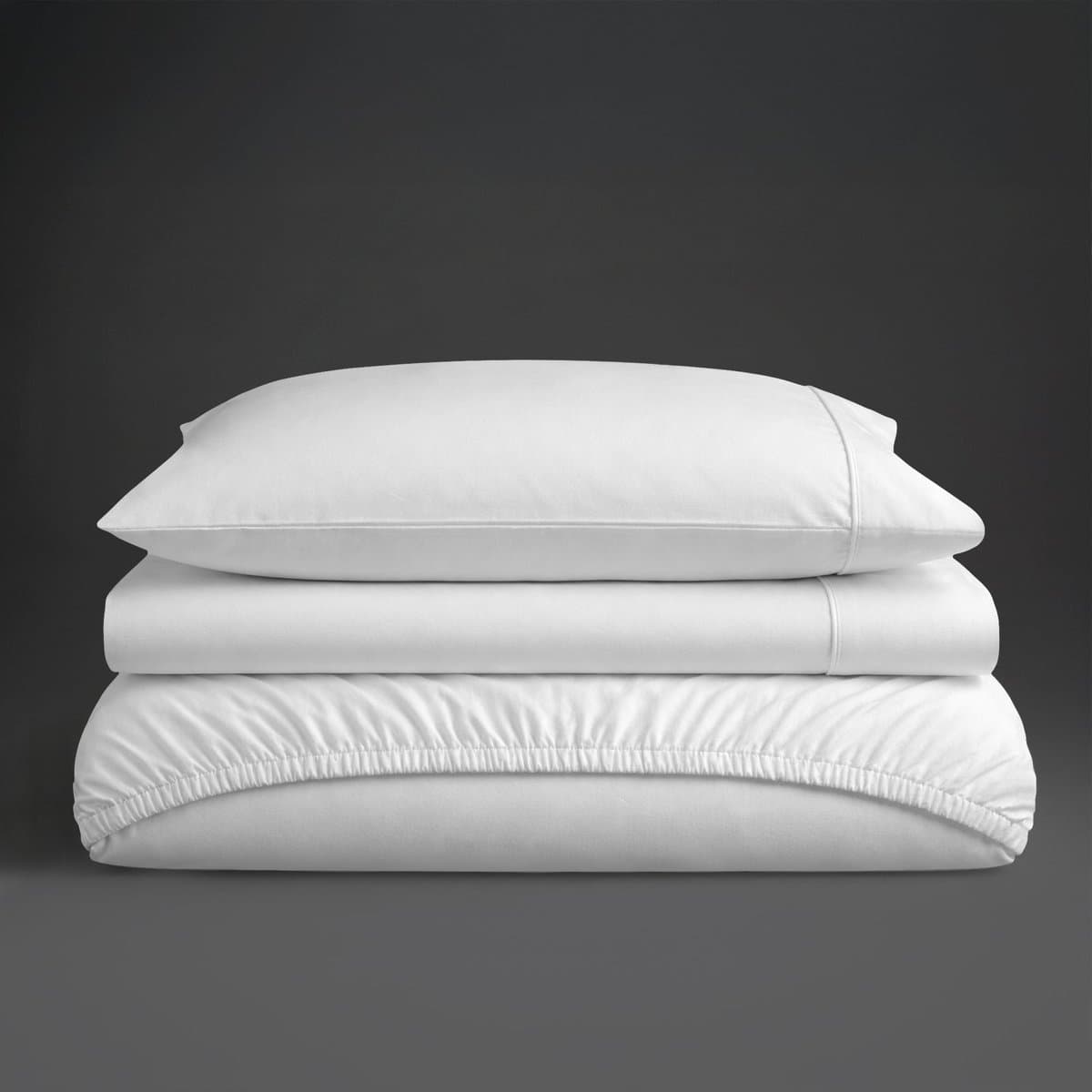 A folded white percale cotton sheet set