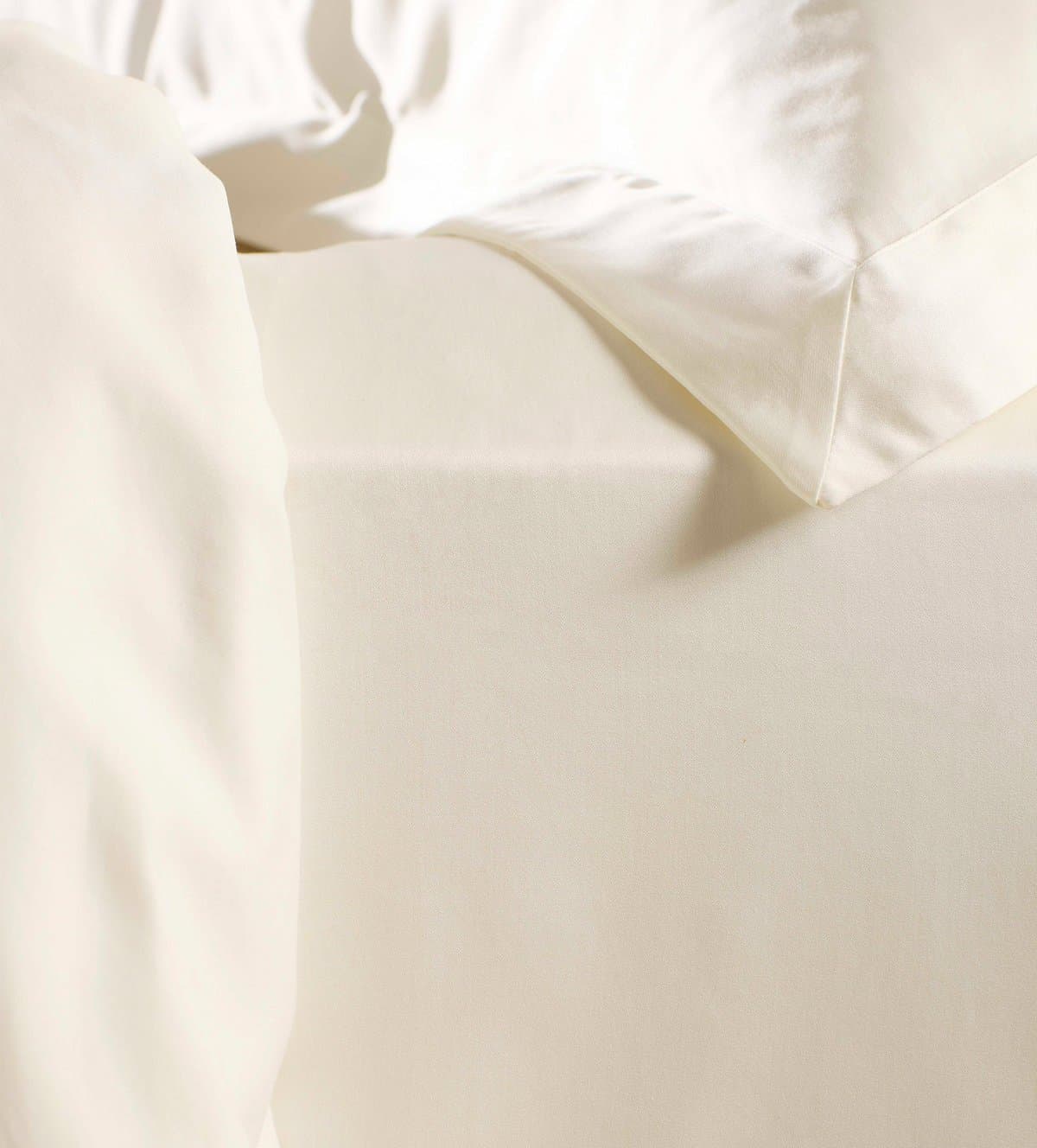 A cream sateen flat sheet and pillow