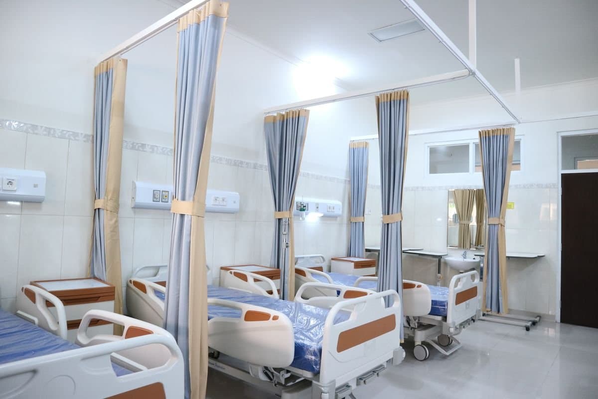 Hospital ward beds with privacy curtains