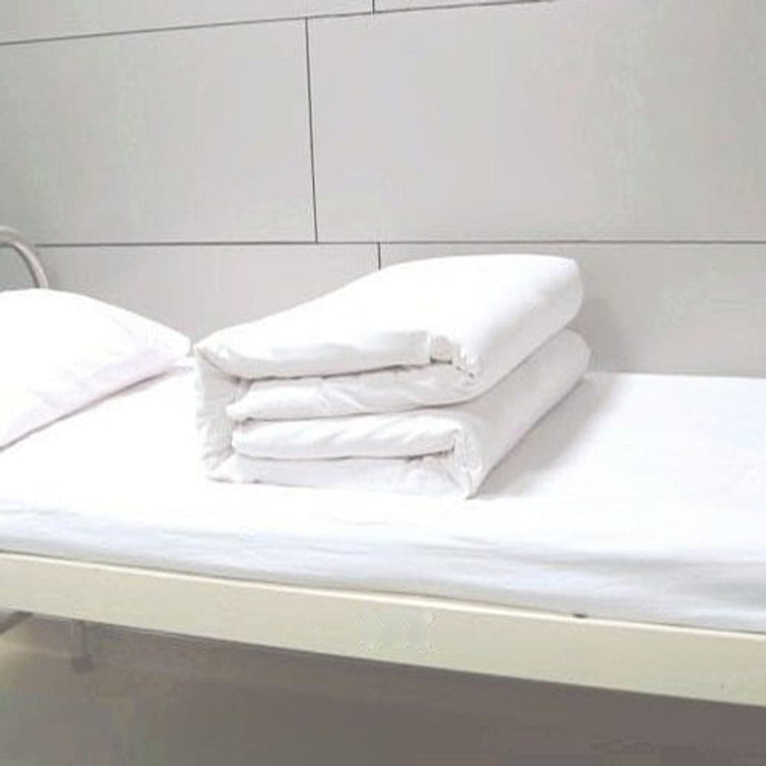 Folded white sheets on a hospital bed