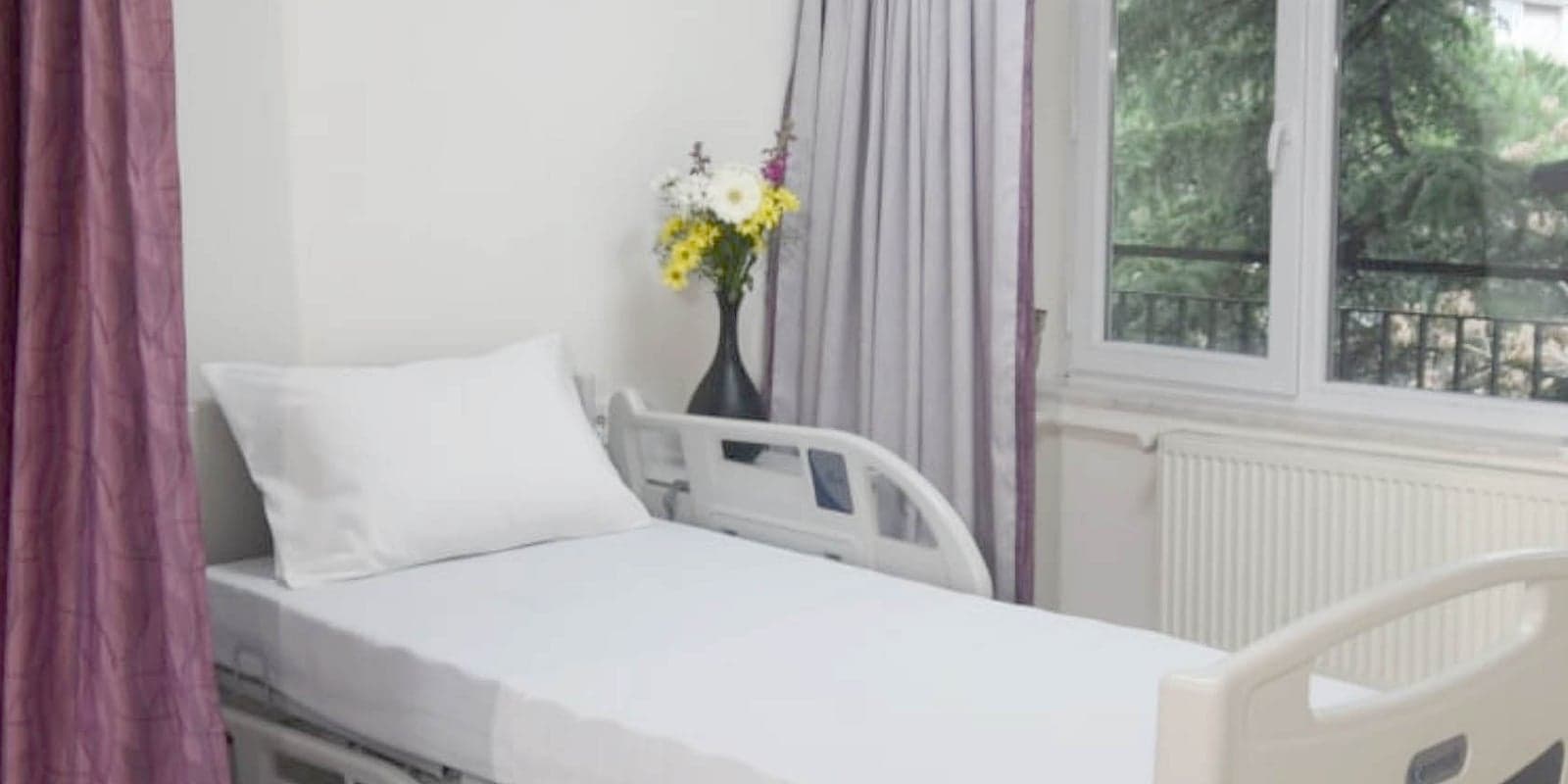 A neatly made bed in crisp white linen