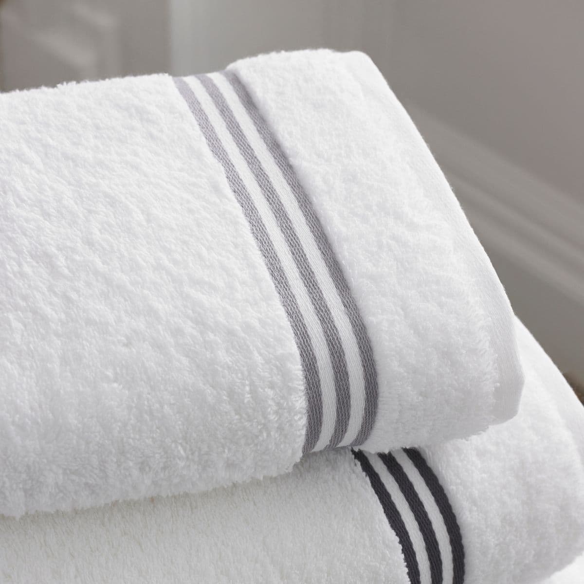 Folded white towels with a fine grey border