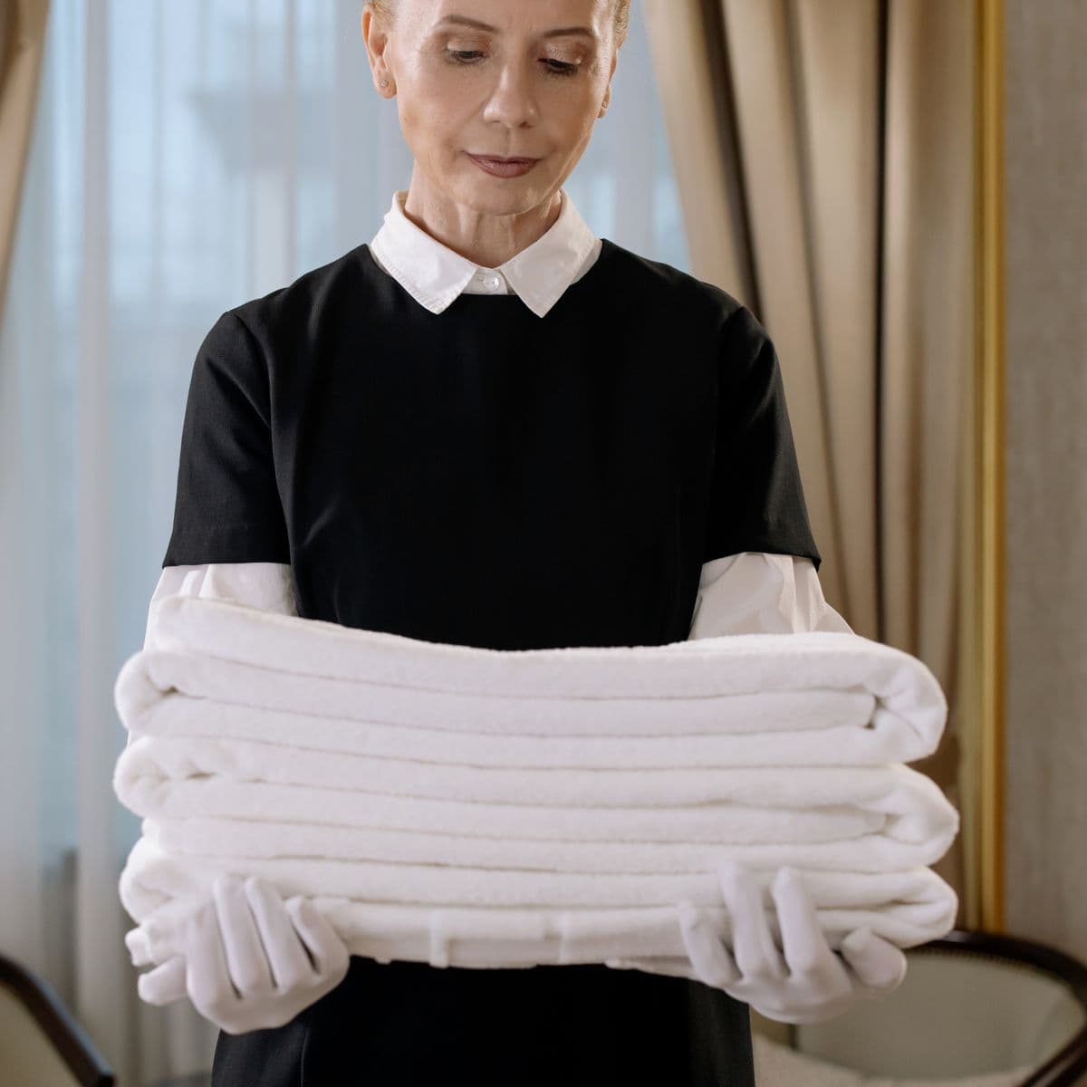A carer carrying folded white towels