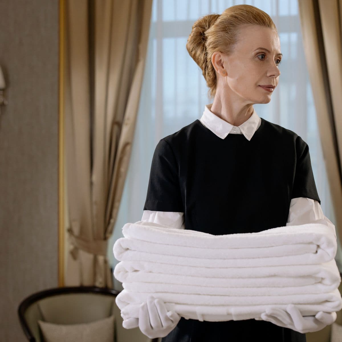 A carer carrying clean folded white towels