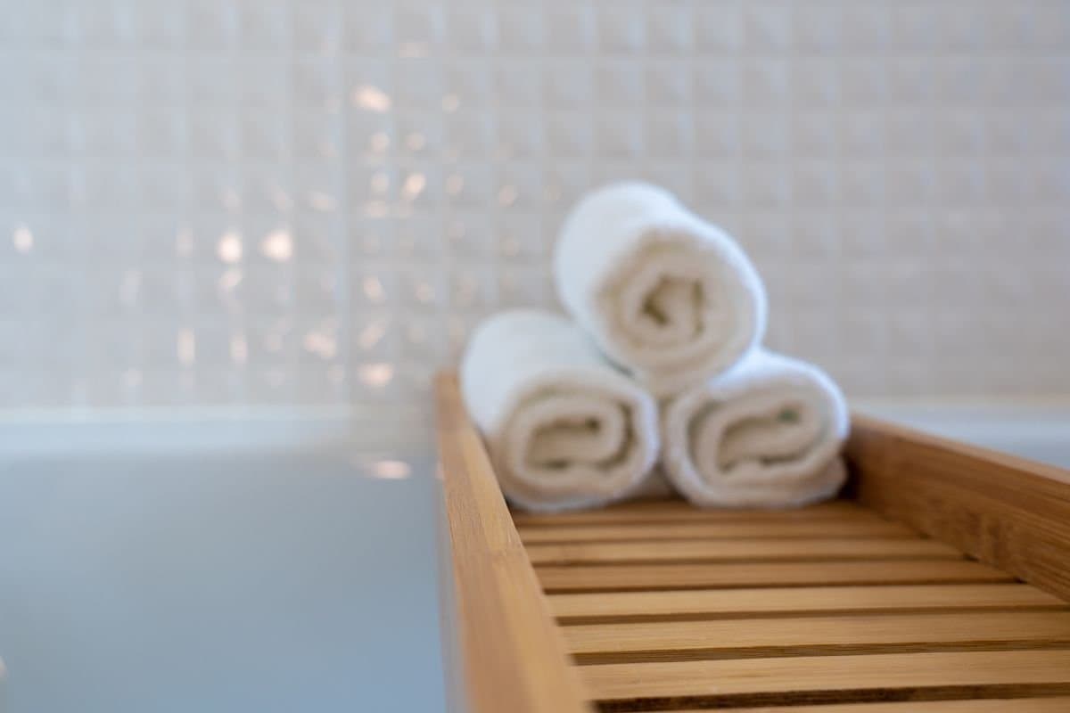 Rolled white towels in a woven basket