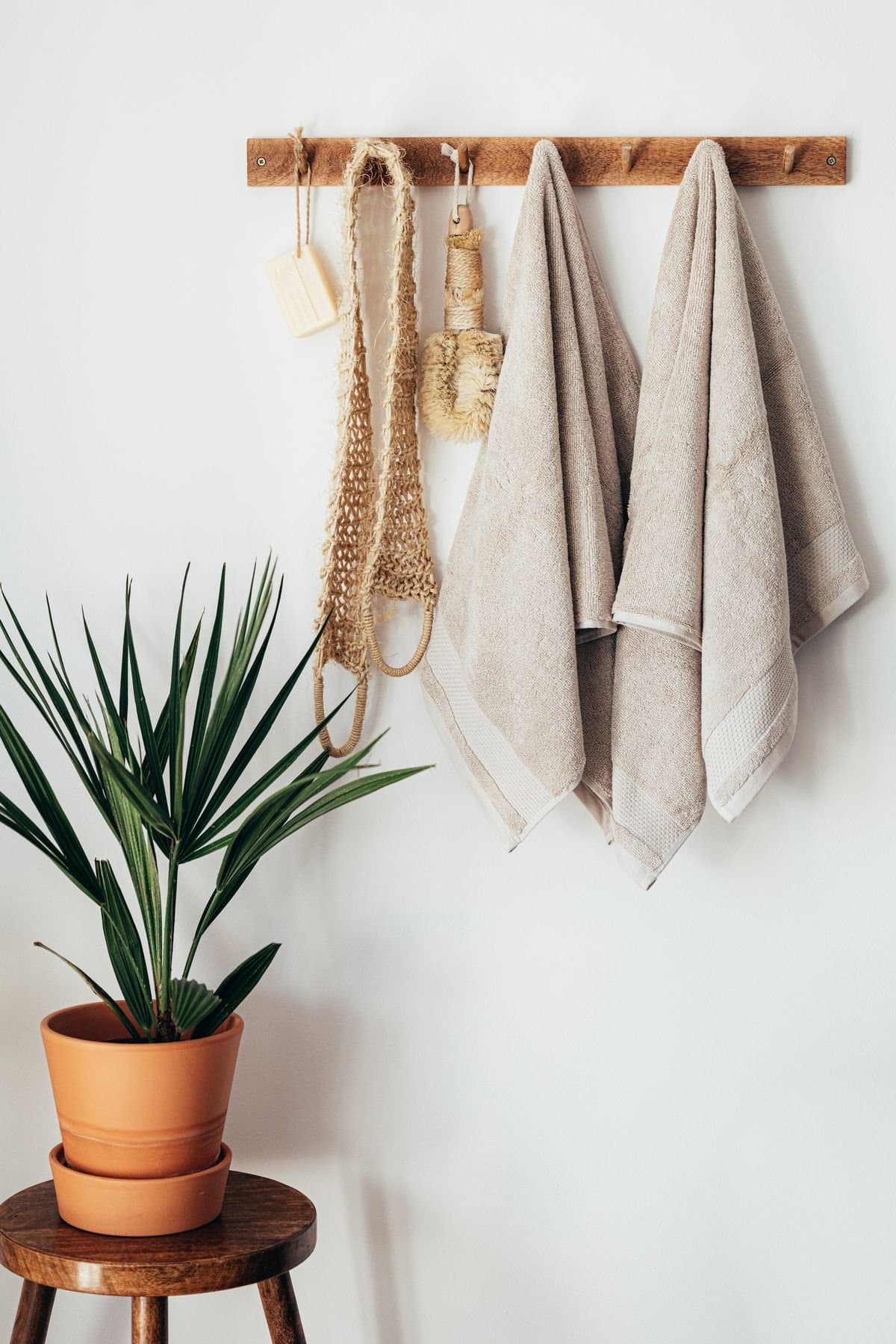 Neutral cotton towels hung on a wall rail