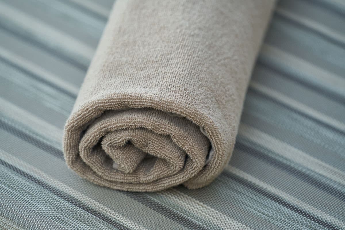 A rolled neutral cotton gym towel