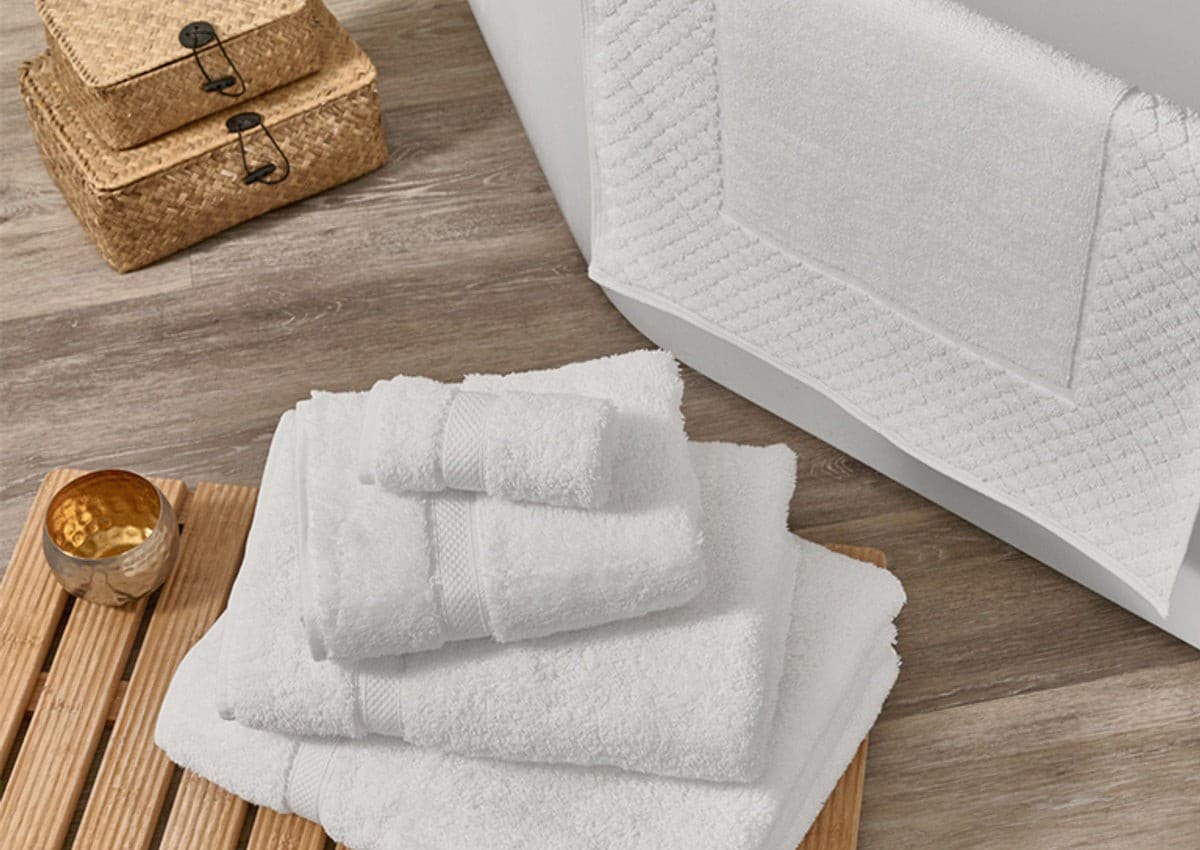 Folded white zero-twist towels with a bath mat