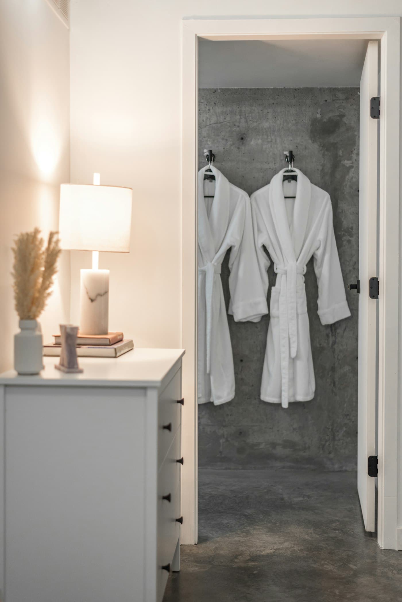 A pair of white shawl-collar robes hung in a spa