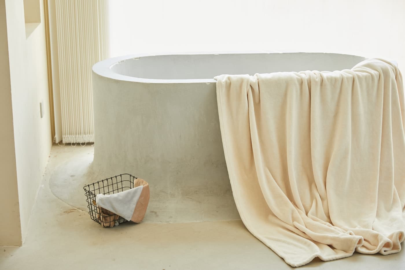Soft cream bath towel draped over a stone tub