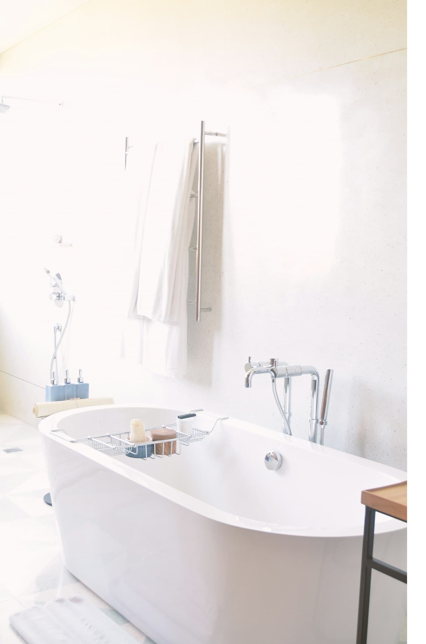 White bath towels on a heated rail with a bath mat
