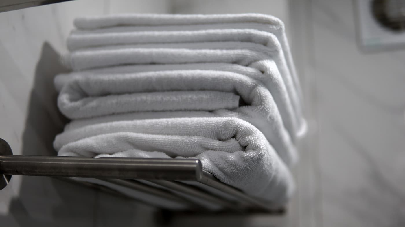 A neat stack of folded white towels on a rail
